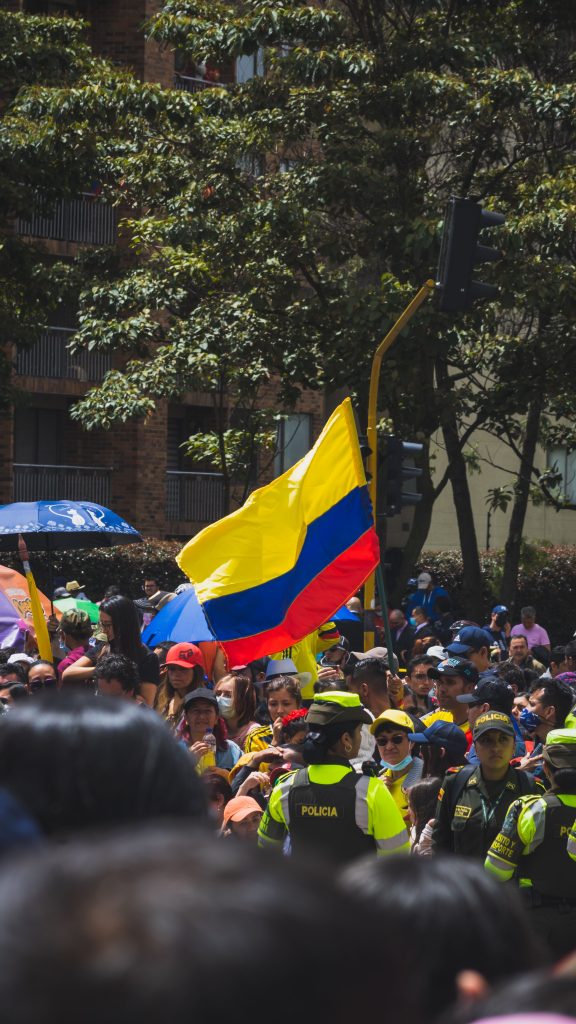 Imagen de movimiento de personas y entre ellas una bandera de colombia como simbolo de patriotismo
